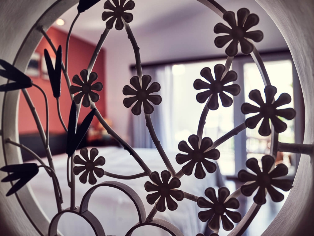 Wrought-iron flower motif and aged timber detail at The Myst Dong Khoi, recalling old Saigon