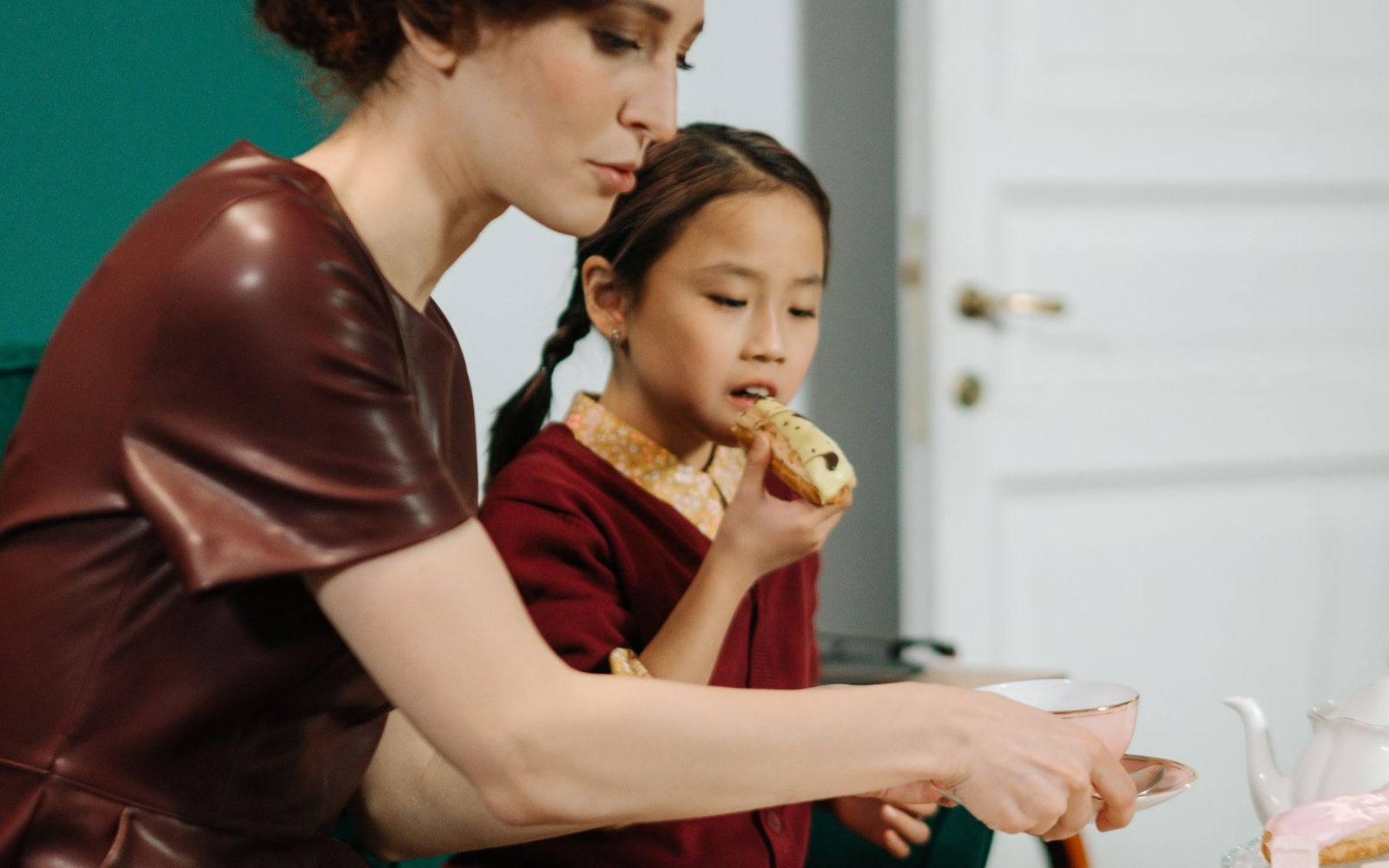 A mother and daughter sharing afternoon tea at a window table