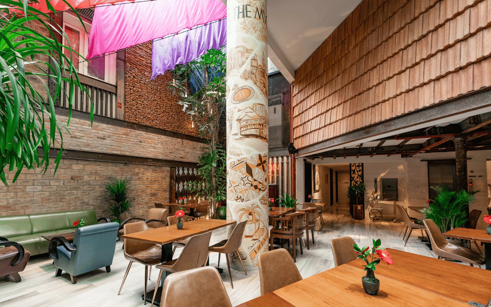 A Cafe for a Work Meeting in the Centre of Saigon 2 The brick courtyard at Bason Cafe Dong Khoi with a hand painted column and greenery