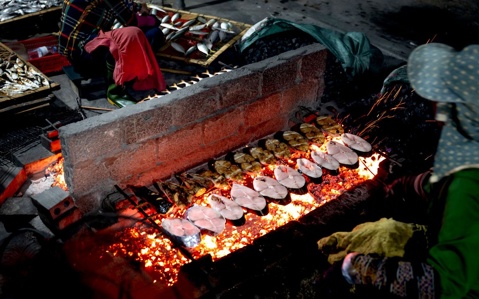 Beyond District 1: Five Saigon Neighborhoods Worth a Half-Day 3 Charcoal grills cooking seafood on Vinh Khanh seafood street in District 4, Saigon at night