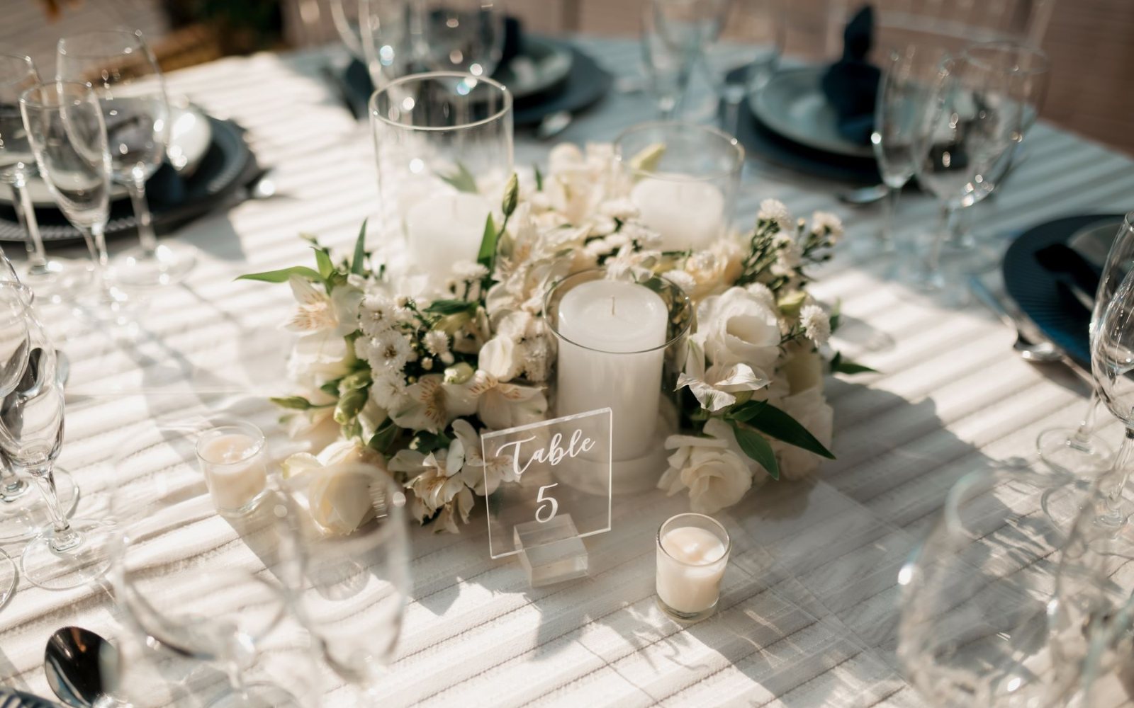 Wedding Trends 2026-2027: Where Celebrations Are Heading 2 A seasonal white flower arrangement with candles on a reception table